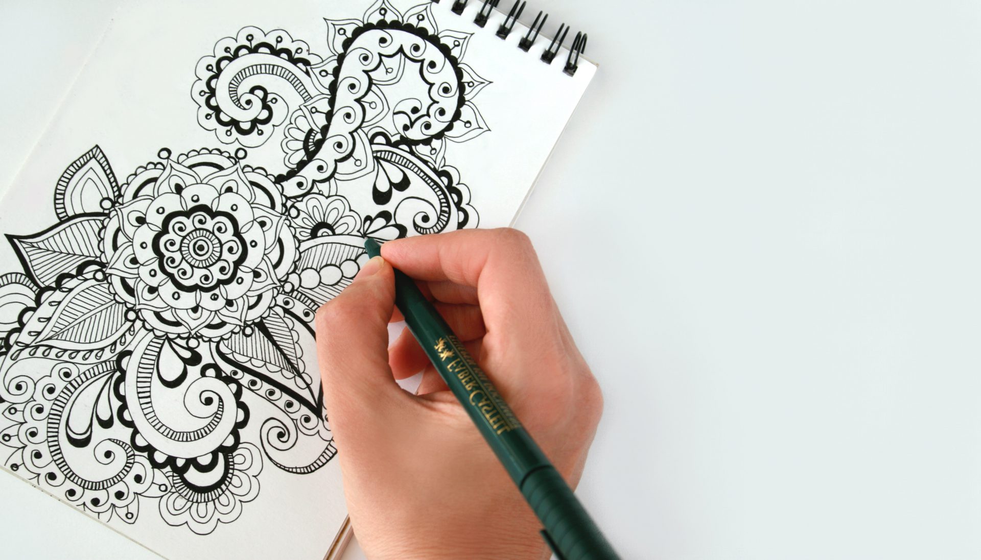 A person drawing with a pencil on paper