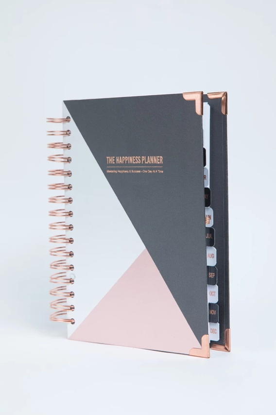 A planner with dividers and a pink triangle on the cover.