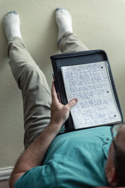 A person holding a notebook on the floor