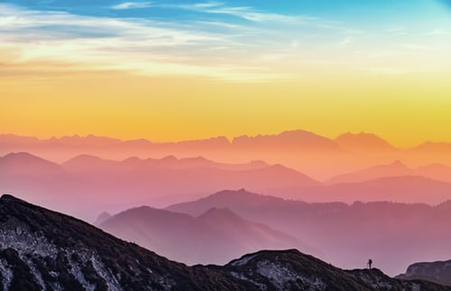 A view of the mountains at sunset from a mountain top.