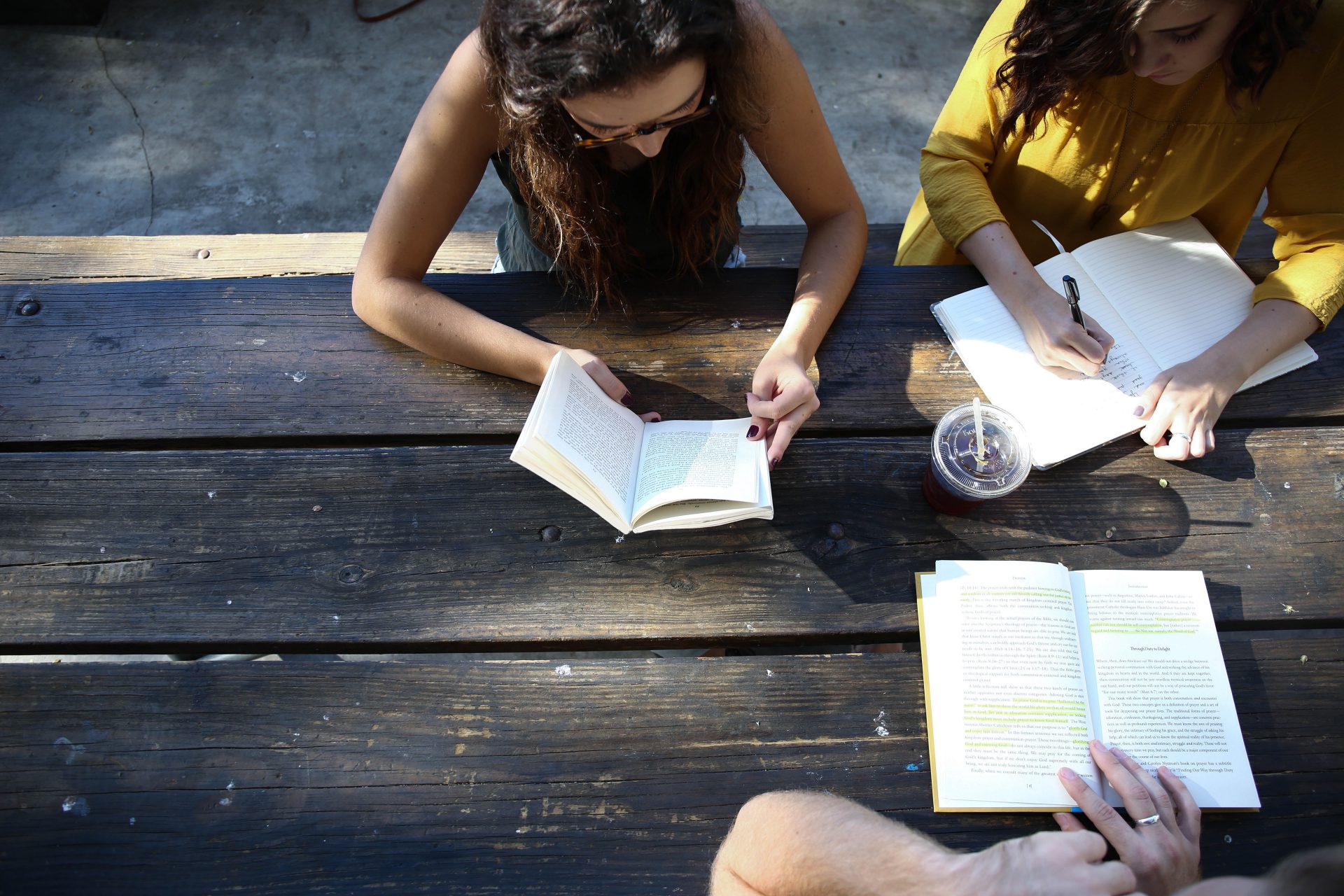 A group of people sitting at a table with books.