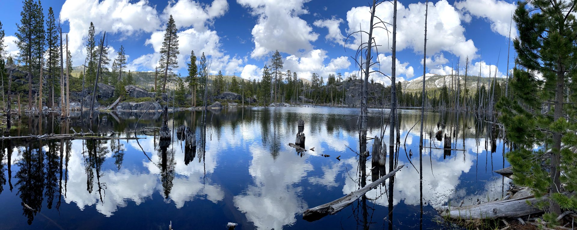 A lake with trees and clouds in the sky.
