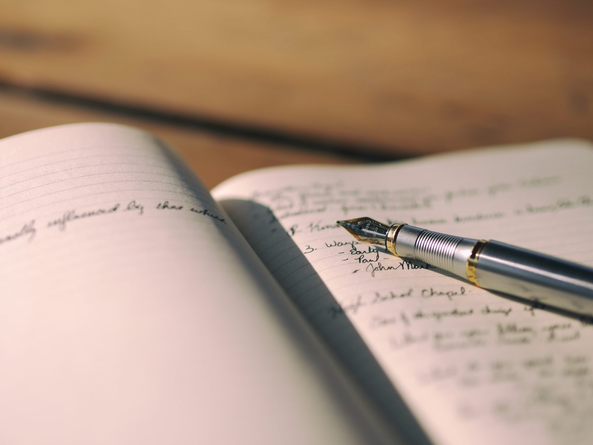 A pen is sitting on top of an open notebook.