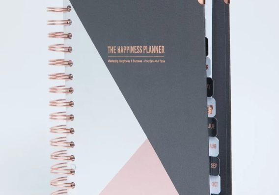 A planner with dividers and a pink triangle on the cover.