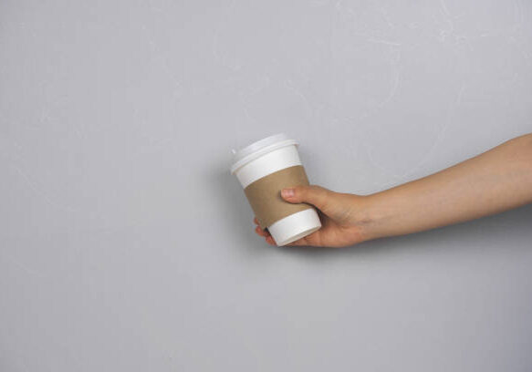 A person holding a cup of coffee in their hand.