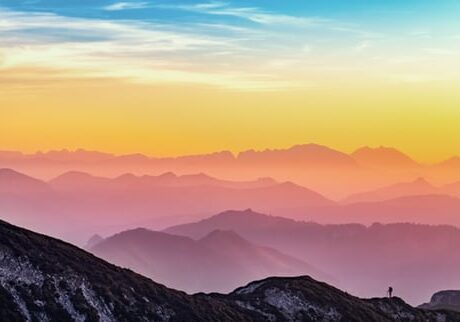 A view of the mountains at sunset from a mountain top.